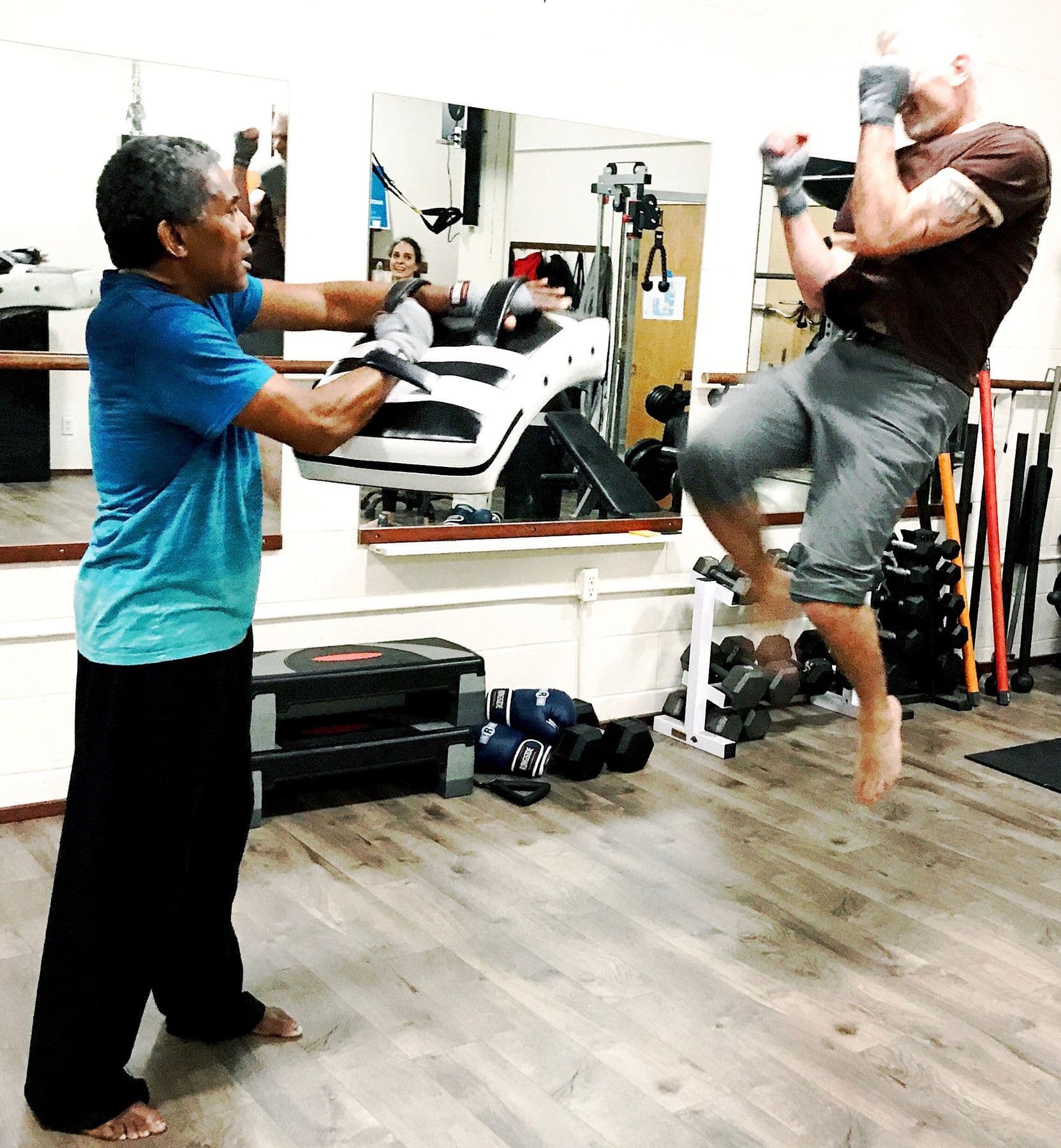 Bill holding pads for a client’s jumping knee strike