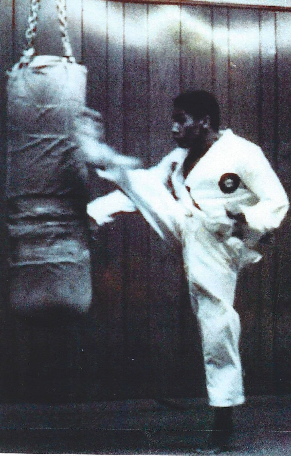 A young Bill Polk throwing a kick at a heavy bag