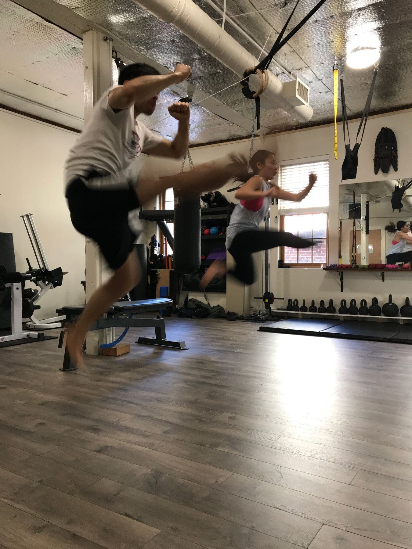 A client mid-air in a flying kick in the training studio